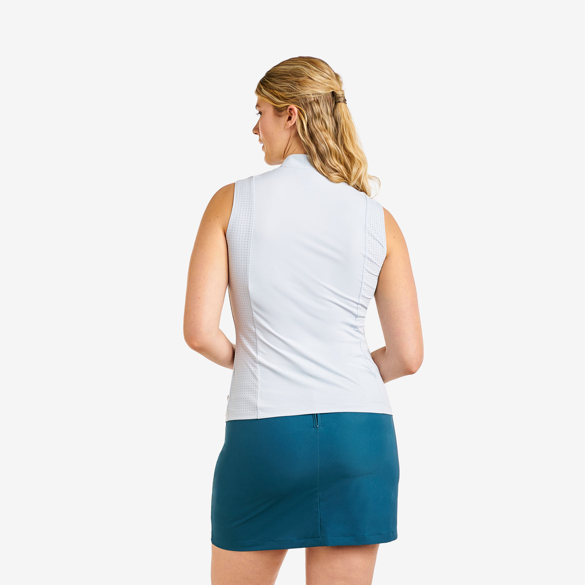 A woman shown from the back wearing a sleeveless white athletic top and a teal mini skirt against a plain light gray studio background.