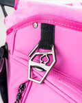 Close-up of a pink Player Preferred Golf Bag featuring a stylish metal tag with the Pins and Aces logo.